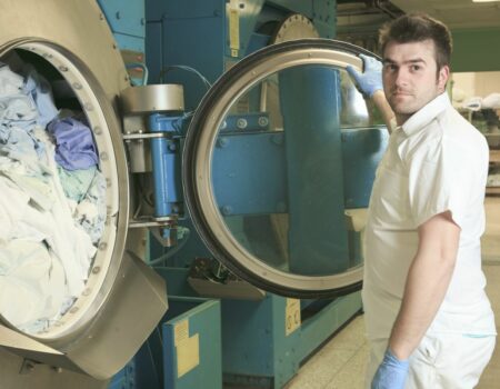 Worker Using Industrial Dryer Needing Commercial Dryer Vent Cleaning in Lancaster, PA